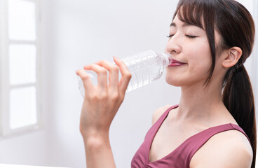 トレーニング中に水を飲む女性