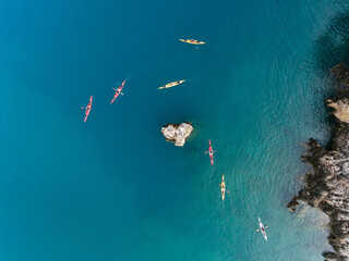Aerial view of a group of sea kayakers in crystal clear water of Mediterranean Sea