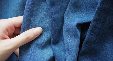 Woman's hand touching denim fabric