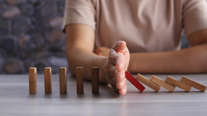 business woman Stop Domino Effect. Risk Management and Insurance Concept, business solution and intervention.
