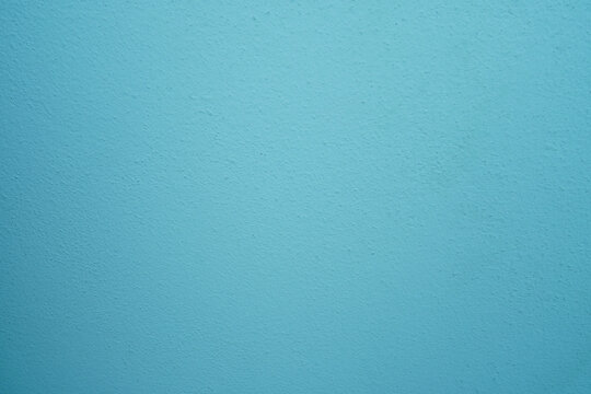 abstract, rough plaster wall texture is light blue for backgroun