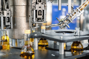 Automatic equipment puts caps on alcohol beverage bottles