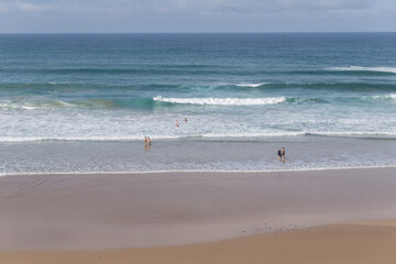 Fototapeta na wymiar Waves on the empty beach with few people