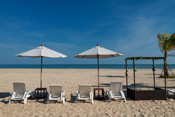 Relax white deck chairs with parasol on beach in summer