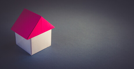 White and red paper house origami isolated on grey background