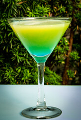 Blue-green cocktail in a martini glass