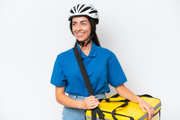 Young caucasian woman with thermal backpack isolated on white background looking side