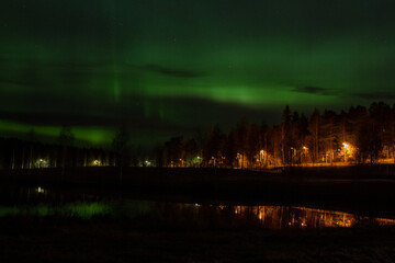 Fototapeta na wymiar Northern lights by the lake in the city of Kuopio, Finland
