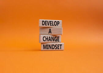 Develop a change mindset symbol. Concept words Develop a change mindset on wooden blocks. Beautiful orange wbackground. Business and Develop a change mindset concept. Copy space.