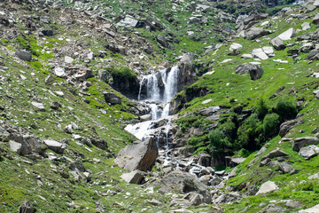 beautiful and spectacular waterfall can be seen enroute rohtang pass near manali, Himachal pradesh, India. A perfect summer morning landscape of lush green and rocky mountains and powerful waterfall.