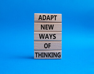 Adapt new ways of thinking symbol. Wooden blocks with words Adapt new ways of thinking. Beautiful blue background. Business and Adapt new ways of thinking concept. Copy space.