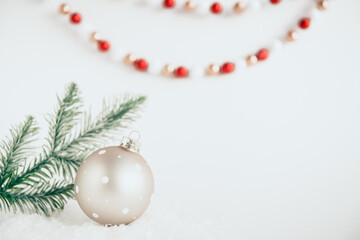 festive christmas ball on white background with snow and fir branches