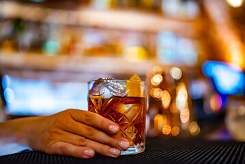 woman bartender hand making negroni cocktail. Negroni classic cocktail and gin short drink with sweet vermouth, red bitter liqueur