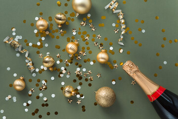 new year decorations golden color with confetti and champagne bottle on color background
