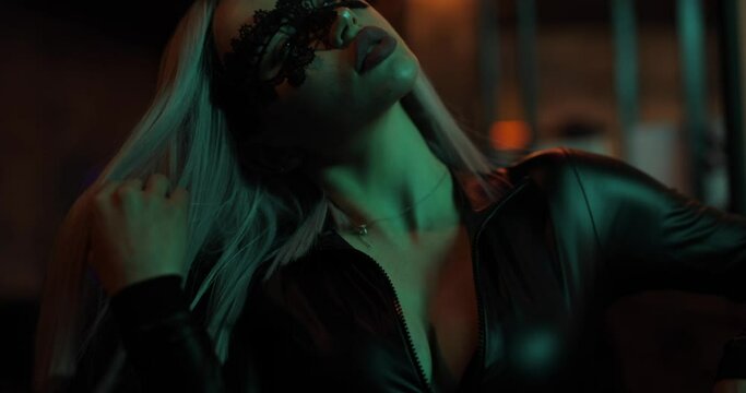 Sexy attractive frisky woman in dress posing in the night bar