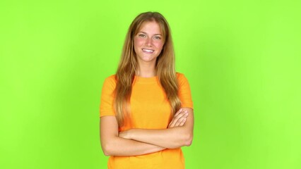 Young pretty blonde woman on green screen chroma key keeping the arms crossed in confident expression over isolated background