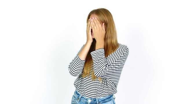 Young pretty blonde woman covering eyes by hands. Surprised to see what is ahead over isolated background