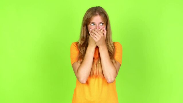 Young pretty blonde woman on green screen chroma key covering mouth with hands. Can not speak over isolated background