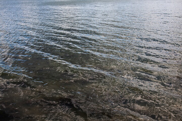 Background image of water in the river, with small waves, for your design or other decorations about nature or travel.
