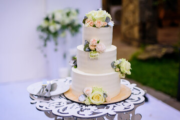 White wedding cake with flowers on table