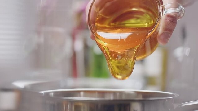 Pouring honey into saucepan, slow motion.
