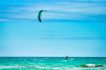 Kite surfer riding waves. Kiteboarding sport.