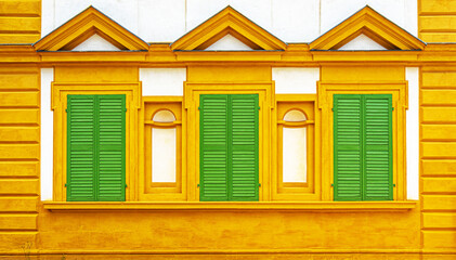 Gelbe Fassade mit grünen Fensterläden