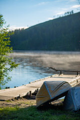 Boats with Mist Rising off a Lake in the Background in Canada