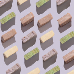 Handmade soap bars pattern with organic ingredients on purple background. Homemade beauty products with natural essential oils from plants and flowers. Body care, aromatherapy.