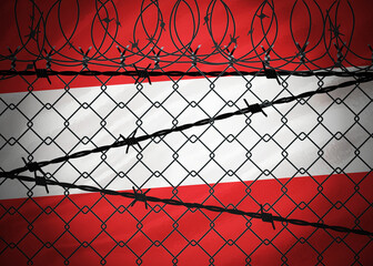 Austria flag behind barbed wire and metal fence