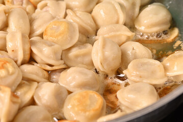 Fried dumplings in a frying pan.