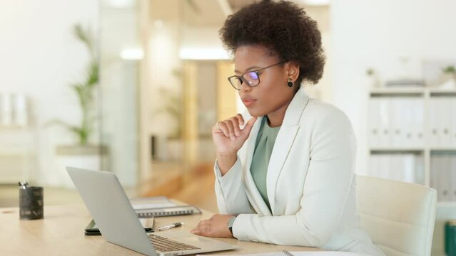 Young business woman browsing on a laptop while working in an office. Focused entrepreneur thinking while typing emails and compiling online reports. Doing research and planning in a startup company