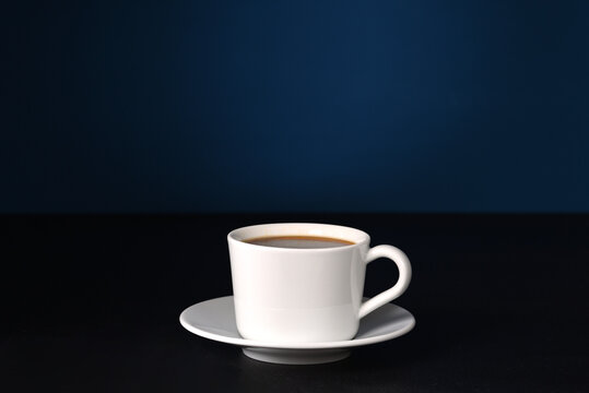 Coffee in white dishes on a dark background.