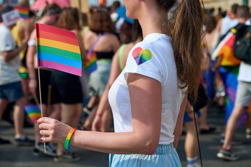 Image of woman holding rainbow flag at LGBT pride parade. Budapest, Hungary 2022