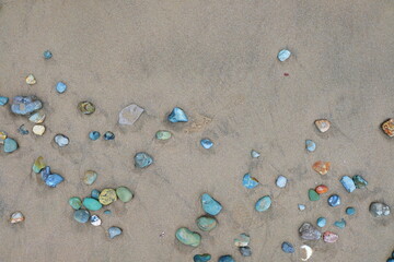 Sea stones on sand. Summer beach background. View from above