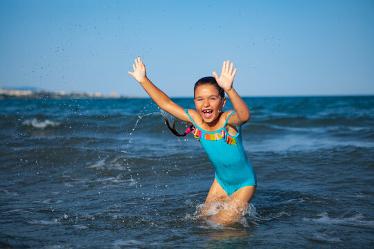happy child jumping on the waves in the sea while relaxing on vacation with parents 