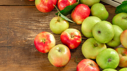 Harvest fresh various red and green apples on wooden background top view with copy space