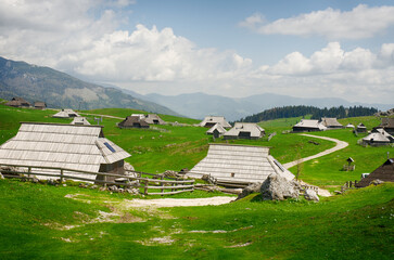 Velika Planina or Big Pasture Plateau in the Kamnik Alps, Slovenia. Mountain cottage hut or house on green hill. Alpine meadow landscape. Eco farming