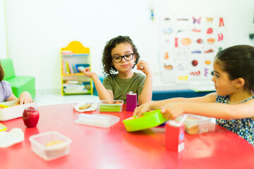 Obraz na płótnie Canvas Preschool child eating his lunch in school