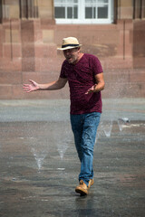 Portrait of man splasching in a public fountain in the street