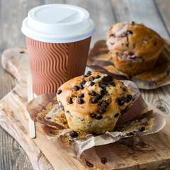 Freshly baked muffins served with coffee in a disposable cup.