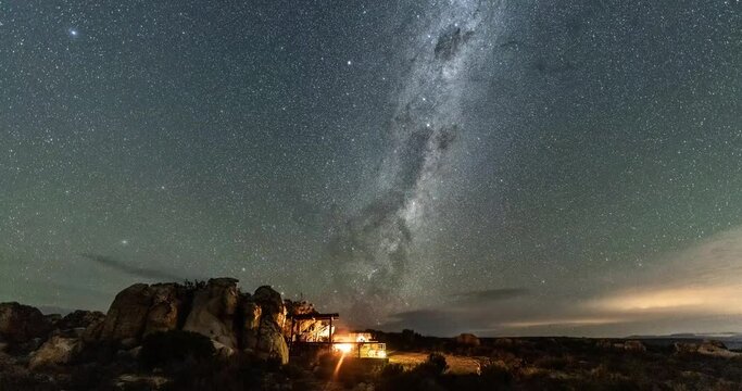 Scenery time lapse of night sky with Milky way and million of stars with camping fire lights
