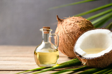 Virgin coconut oil with coconut fruits on wooden table.