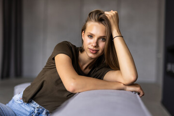 Portrait of a young female freelancer sitting on the couch and working on project, watching movie on laptop, studying, blogging, resting and chatting online.