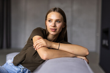 Obraz premium Portrait of a young female freelancer sitting on the couch and working on project, watching movie on laptop, studying, blogging, resting and chatting online.