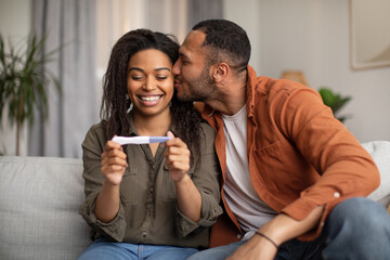 Happy African American Couple Holding Positive Pregnancy Test At Home - obrazy, fototapety, plakaty