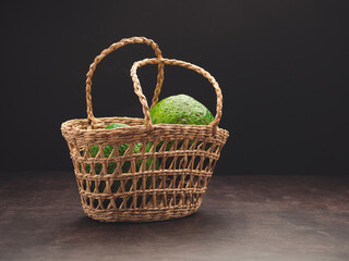 Fototapeta na wymiar A basket of avocados with a black background
