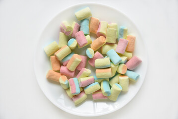 Colorful sweet marshmallows on a white plate. Delicious marshmallows for coffee.
