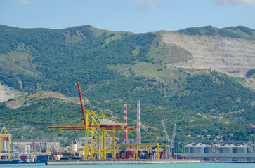 Industrial zone in the seaport. Cranes, towers, pipes, cargo ships. Transit zone.