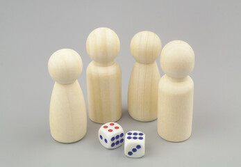 Gambling and playing games concept. Wooden figures of people and dices on gray background.	